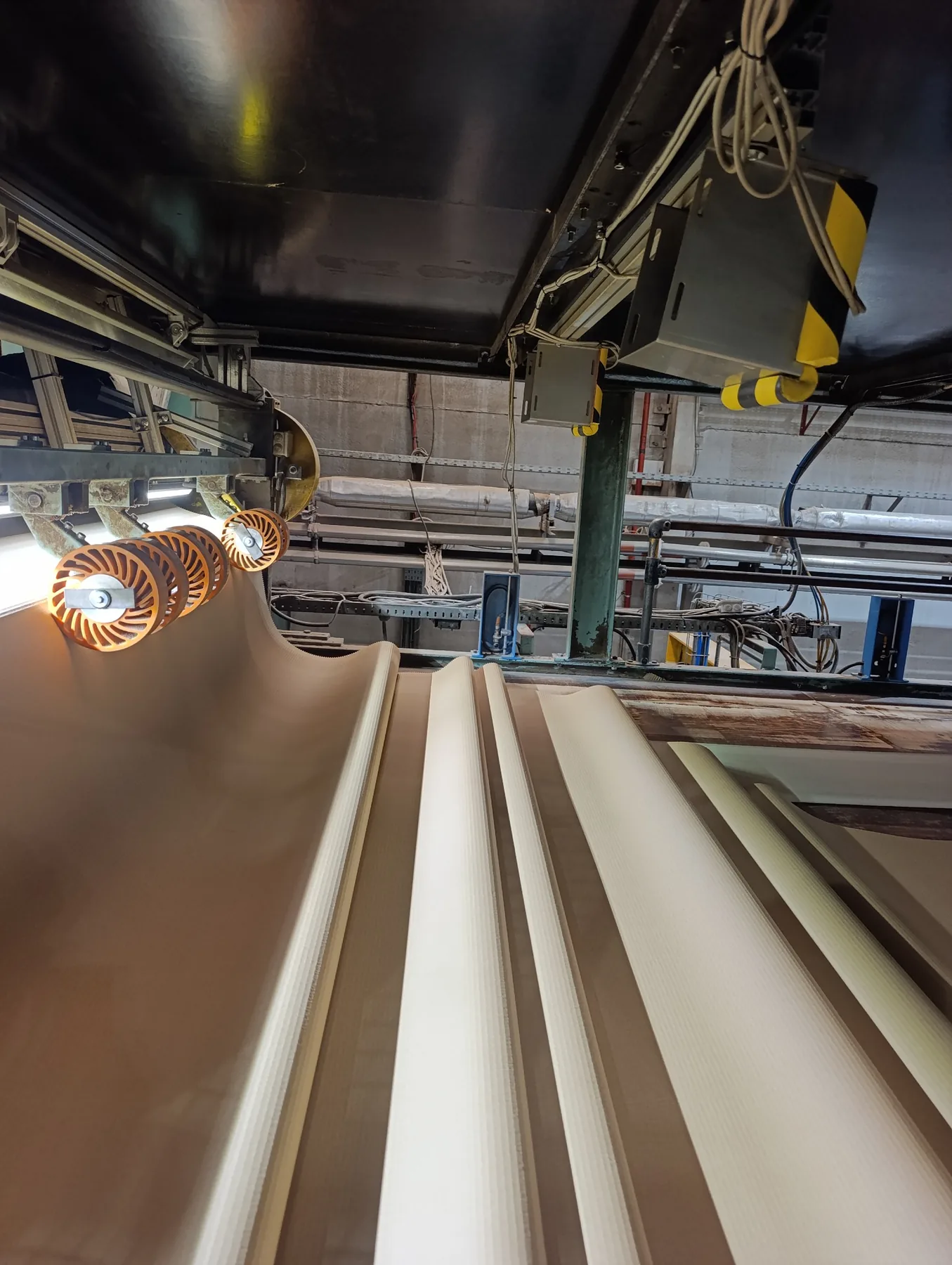 Corrugated board moving through an illuminated inline inspection area