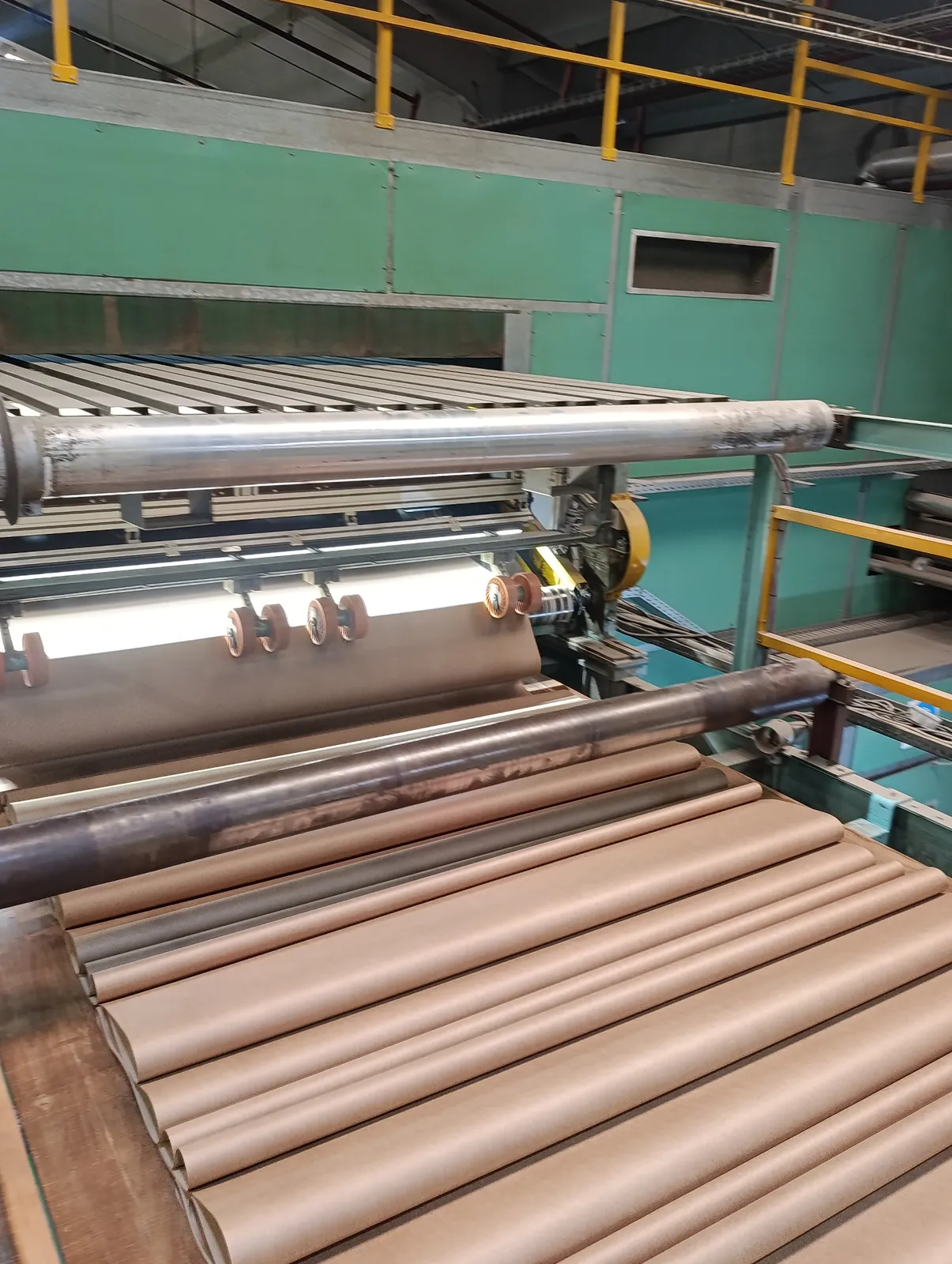Packaging production factory with corrugated material rolls and converting equipment