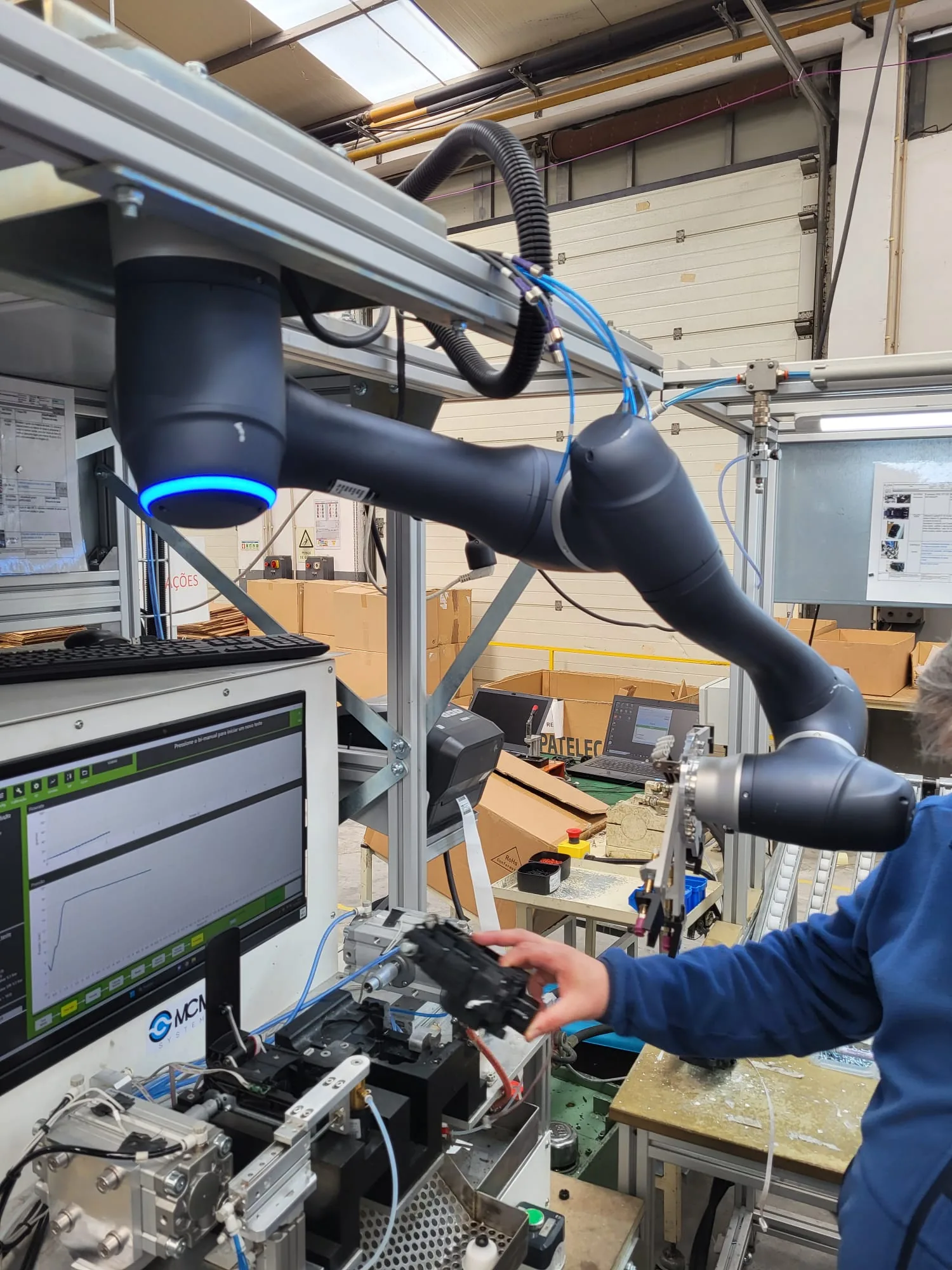 Close view of MCM robot-assisted test handling with production HMI and dedicated fixture